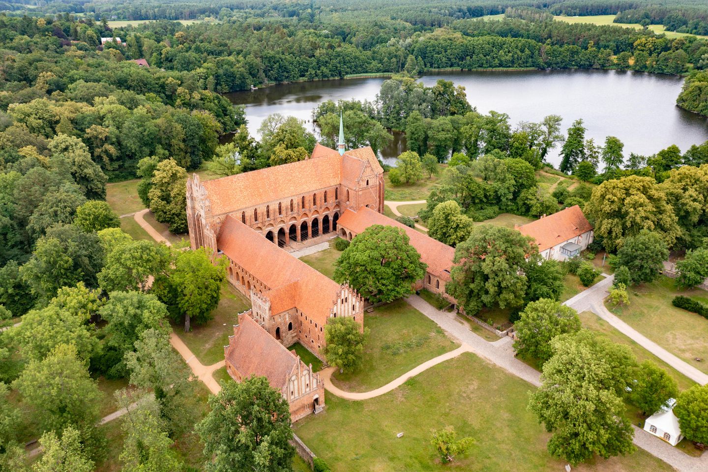 Luftaufnahme der Backsteinklosteranlage mit Wald und See