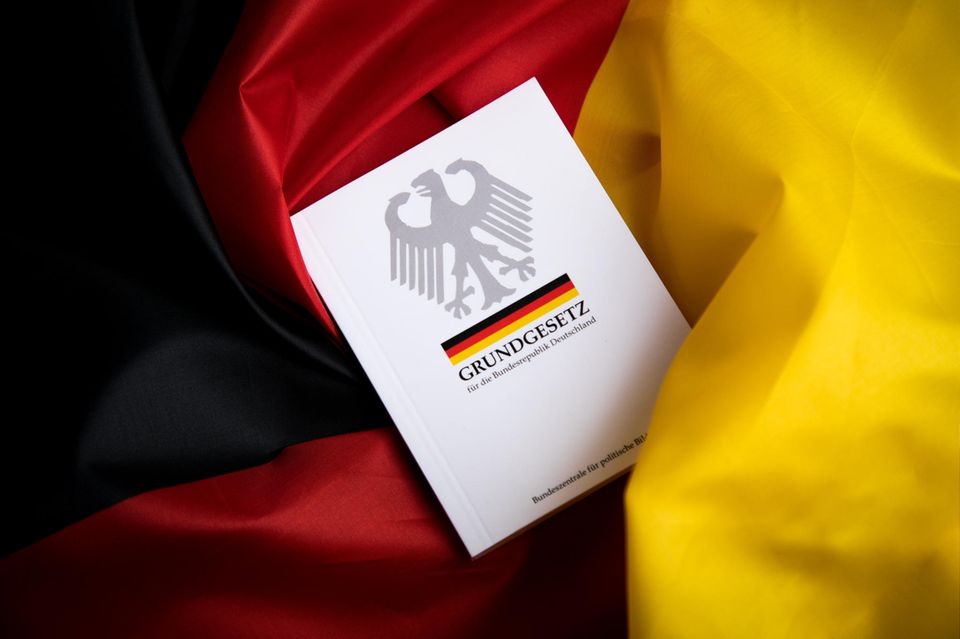 Grundgesetz liegt auf Deutschland Flagge