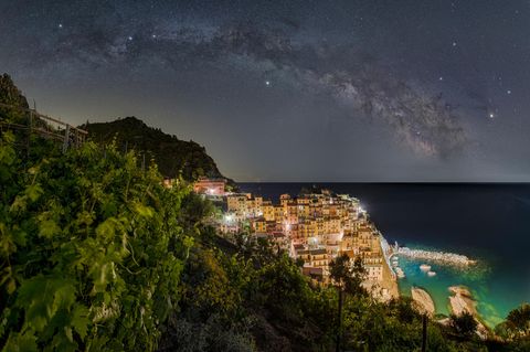 Nachthimmel mit Milchstrasse über Küstenort Manarola, Italien