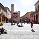 Platz. auf dem Menschen sitzen umrahmt von  alten Gebäuden