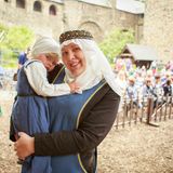 eine Frau trägt ein kleines Mädchen, beide tragen Kostüme