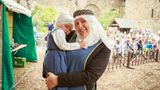 eine Frau trägt ein kleines Mädchen, beide tragen Kostüme
