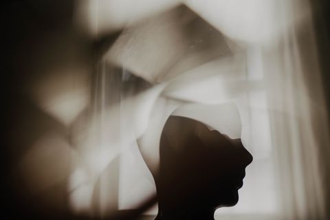Silhouette eines Kopfes mit prismatischen Bildelementen vor einem Fenster.