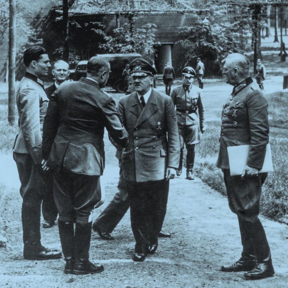 schwarz-weiß Fotografie zeigt Stauffenberg und Hitler mit weiteren Männern