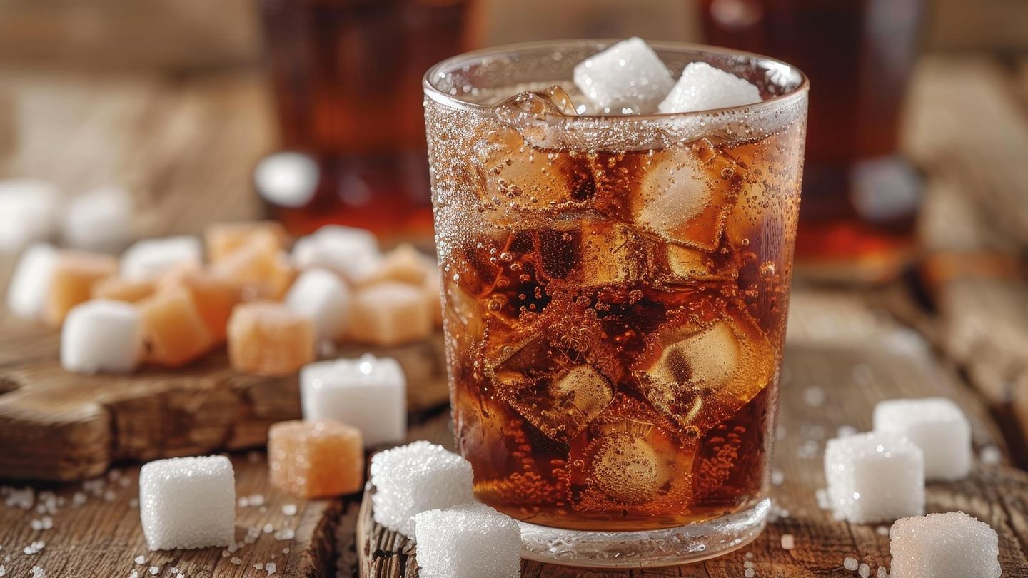 Ein Glas Cola ist mit Zuckerwürfeln gefüllt