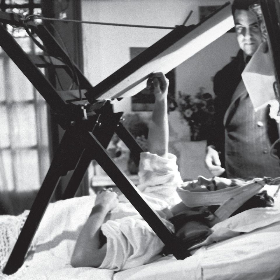 Schwarz-weiß Fotografie zeigt Frida Kahlo schwerkrank im Bett
