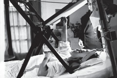 Schwarz-weiß Fotografie zeigt Frida Kahlo schwerkrank im Bett