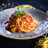 Tagliatelle Bolognese mit Parmesan auf einem Teller