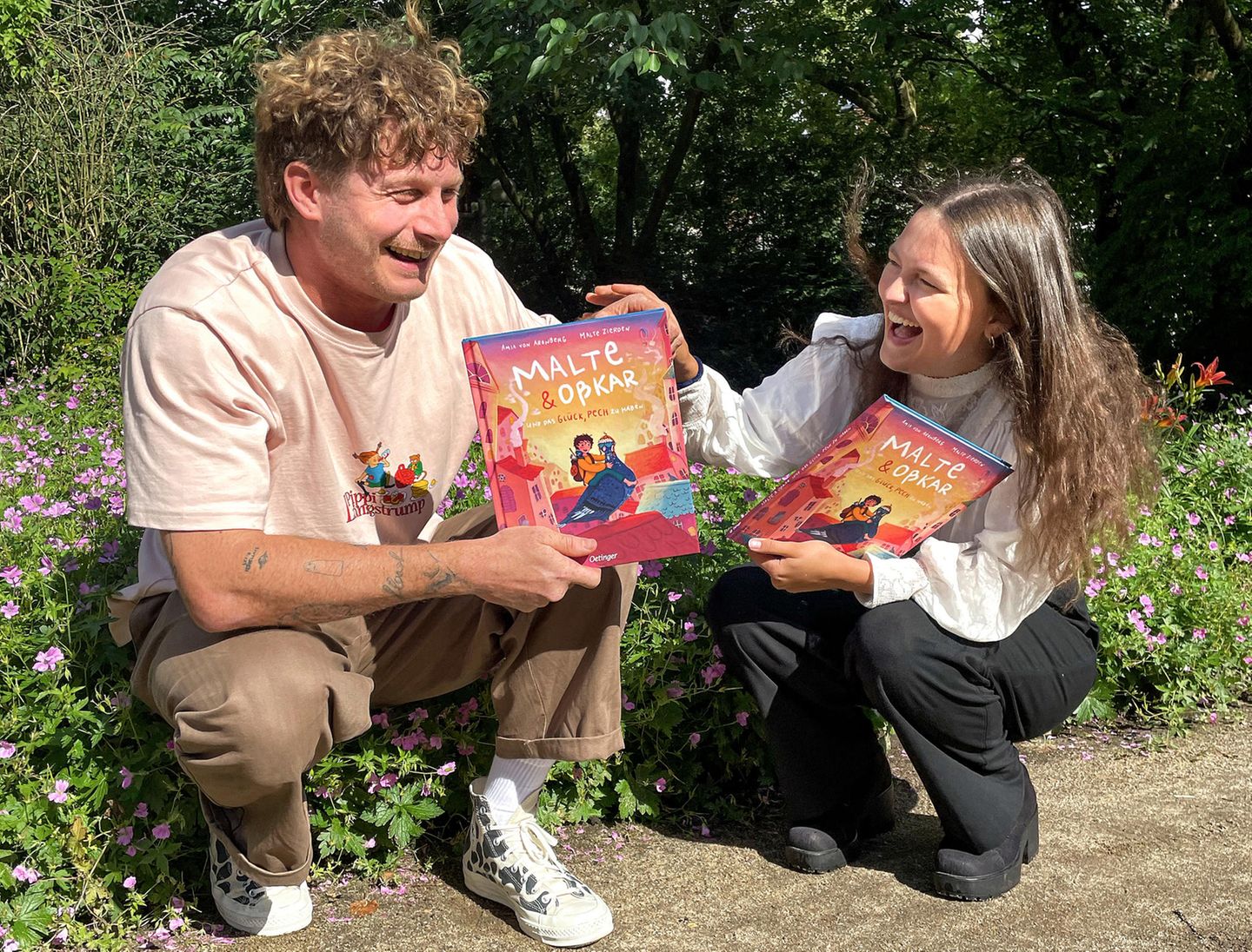 Malte Zierden und Amia von Arenberg halten ihr neu veröffentlichtes Buch in der Hand