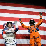 Vier Menschen stehen vor einer US-Flagge, zwei davon in Raumanzügen