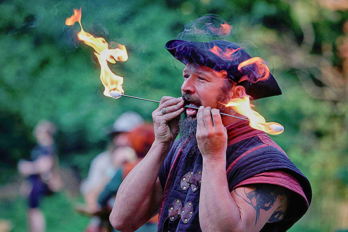 ein Mann, der mit seinem Mund Tricks mit dem Feuer vorführt