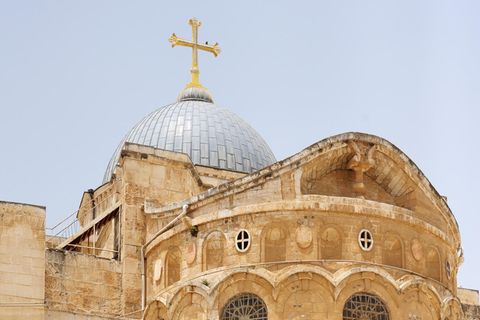 Ein Blick von außen auf die Grabeskirche in Jerusalem mit jemandem, der davor geht