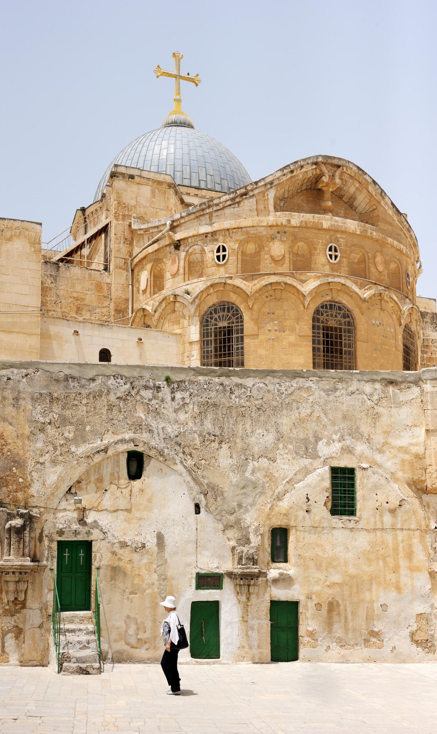 Ein Blick von außen auf die Grabeskirche in Jerusalem mit jemandem, der davor geht