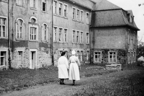 Zwei Krankenschwestern gehen entlang einer "Tripperburg"