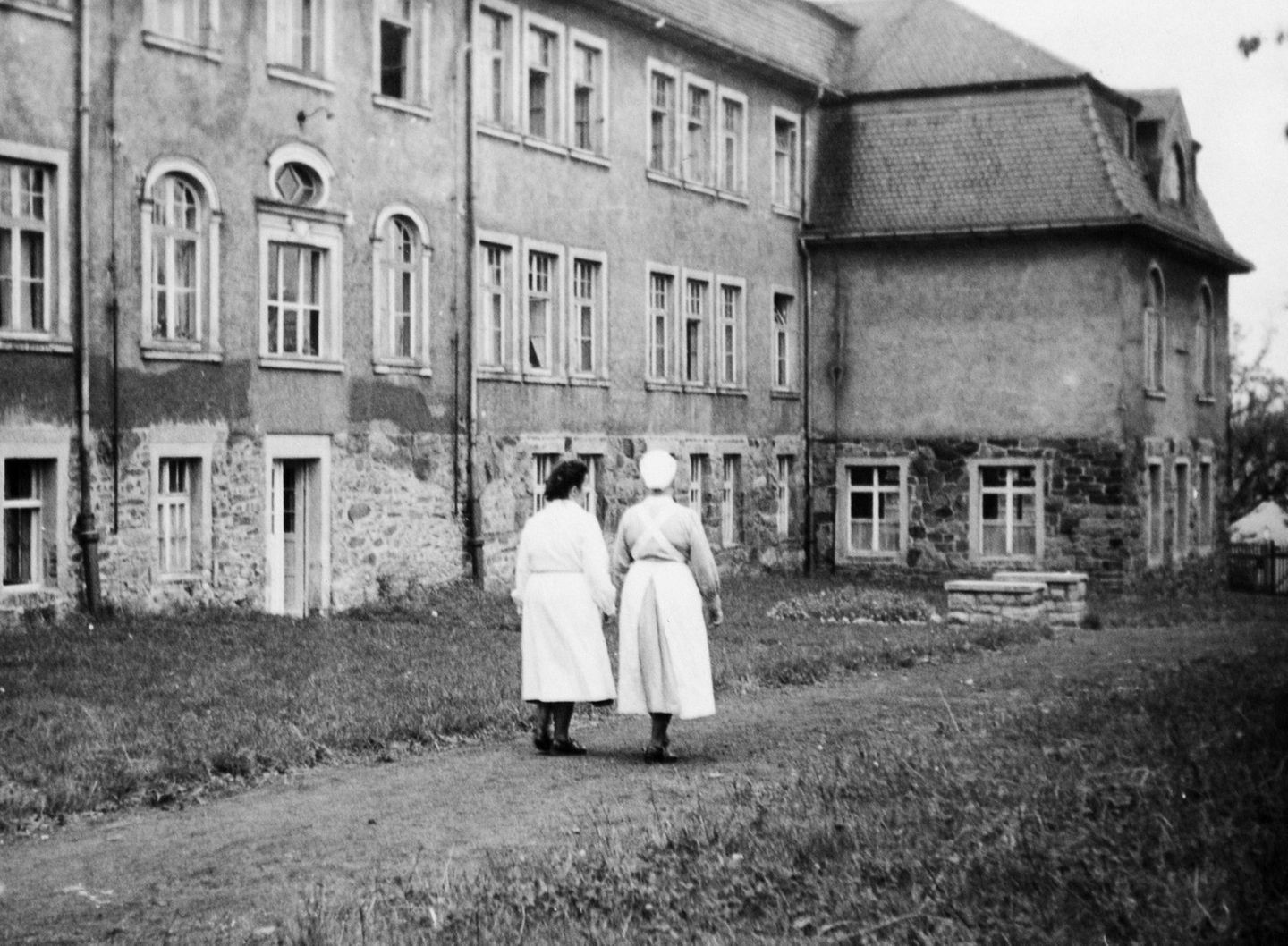 Zwei Krankenschwestern gehen entlang einer "Tripperburg"