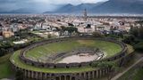 Das Amphitheater wurde 70 v. Chr. erbaut und bot bis zu 20.000 Zuschauerinnen und Zuschauern Platz. Das Bauwerk befindet sich in einem Randbezirk fernab des dicht bebauten Zentrums von Pompeji, um den Menschenmengen den Zutritt zu erleichtern und die Innenstadt nicht zu verstopfen