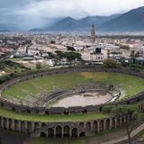 Das Amphitheater wurde 70 v. Chr. erbaut und bot bis zu 20.000 Zuschauerinnen und Zuschauern Platz. Das Bauwerk befindet sich in einem Randbezirk fernab des dicht bebauten Zentrums von Pompeji, um den Menschenmengen den Zutritt zu erleichtern und die Innenstadt nicht zu verstopfen