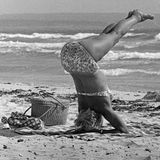 Frau macht Yoga am Strand