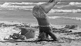 Frau macht Yoga am Strand