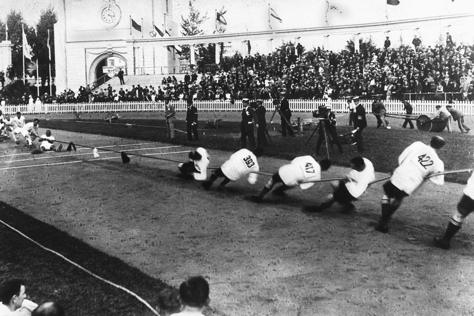 Zwei Männermannschaften beim Tauziehen 1920 vor großem Publikum