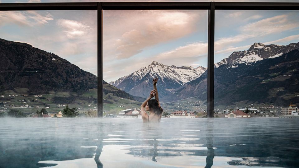 Frau im Wasser vor Bergpanorama