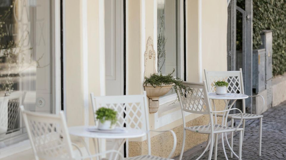 Tische mit Stühlen vor Café