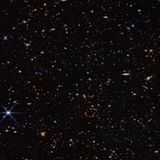 Foto des Alls mit viel Dunkler Fläche und vereinzelten Sternen und Galaxien