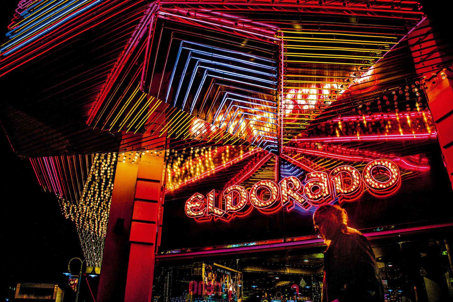 Traum von Eldorado Verspiegelter, bunt beleuchteter Eingang mit dem Schriftzug "Eldorado" bei Nacht