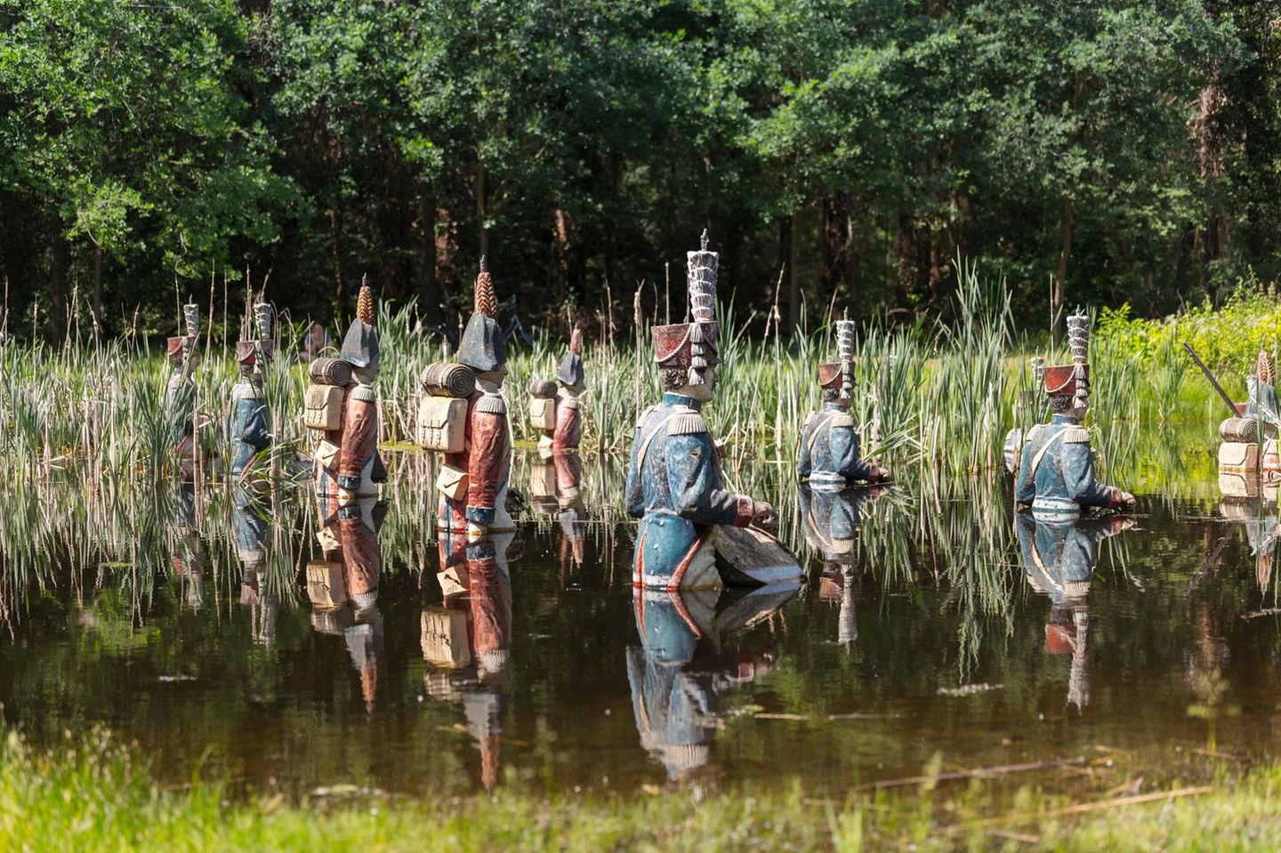 Viele militärisch anmutende Statuen, die halb im Wasser versunken sind