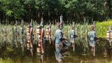 Viele militärisch anmutende Statuen, die halb im Wasser versunken sind