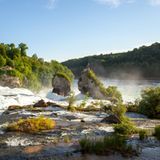 Die Landschaft des Rheinfalls im Abendlicht, Blick über das Wasser in Richtung des Schlosses Laufen