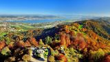 Drohnen-/Luftaufnahme: Blick auf den herbstlichen Uetliberg, im Hintergrund sieht man den Zürichsee und die Albiskette.