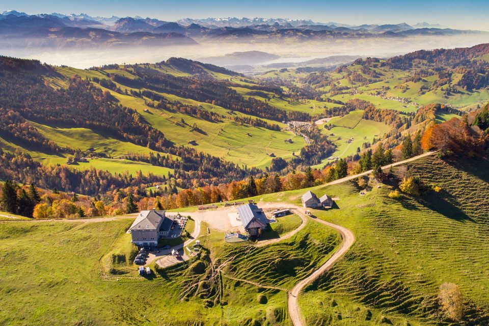 Luftbild: Blick auf die herbstliche Chrüzegg mit Hütten und Bergpanorama 1.7778
