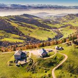 Luftbild: Blick auf die herbstliche Chrüzegg mit Hütten und Bergpanorama