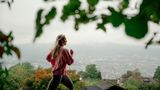 Junge, blonde Frau joggt vor Züricher Stadtpanorama im Hintergrund