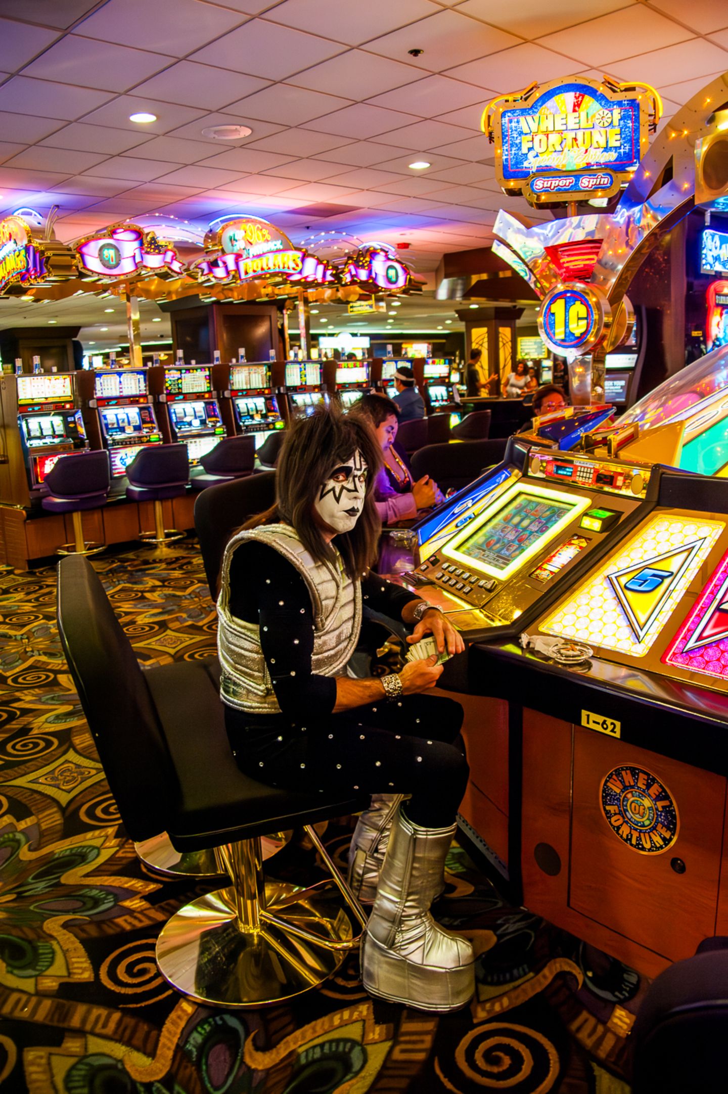 Ein Mann in Kostüm und Schminke eines Sängers der Rockband Kiss an einem Automaten