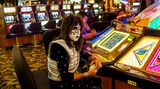 Ein Mann in Kostüm und Schminke eines Sängers der Rockband Kiss an einem Automaten