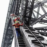 Menschen klettern mit Sicherheitsketten auf die Brücke