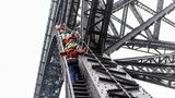 Menschen klettern mit Sicherheitsketten auf die Brücke