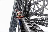 Menschen klettern mit Sicherheitsketten auf die Brücke