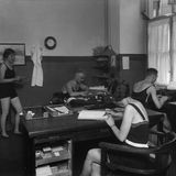 In einem Büro arbeiten Männer und Frauen in Badeanzügen