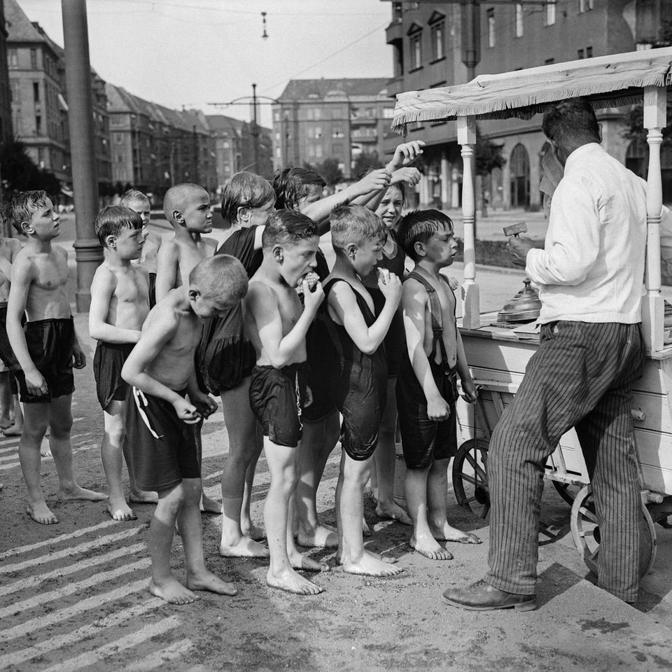 Kinder in Badekleidung stehen vor einem Eiswagen an