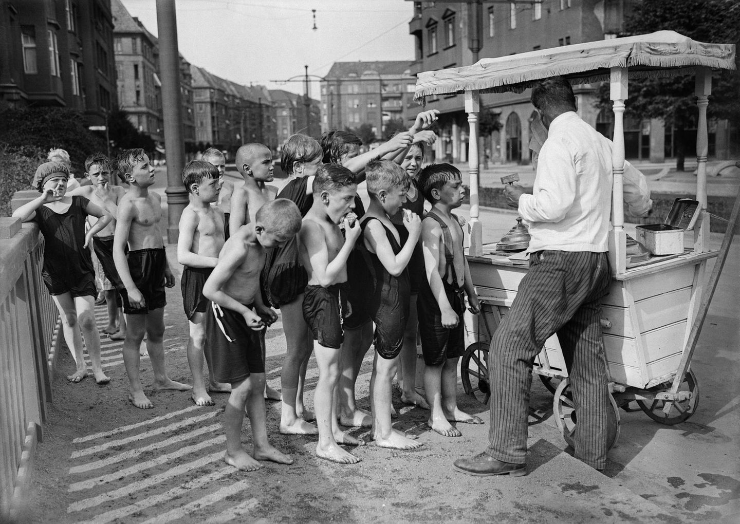 Kinder in Badekleidung stehen vor einem Eiswagen an