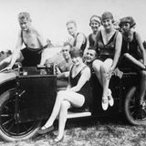 Acht Ausflügler posieren auf einem offenen Auto