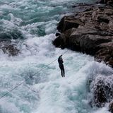 Jemand macht eine Seilrutsche über rauem Wasser