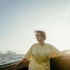 Eine reife Frau sitzt auf dem Boot