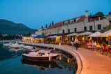 Restaurants an der Kaimauer eines kleinen Hafens in Kroatien