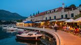 Restaurants an der Kaimauer eines kleinen Hafens in Kroatien
