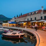 Restaurants an der Kaimauer eines kleinen Hafens in Kroatien