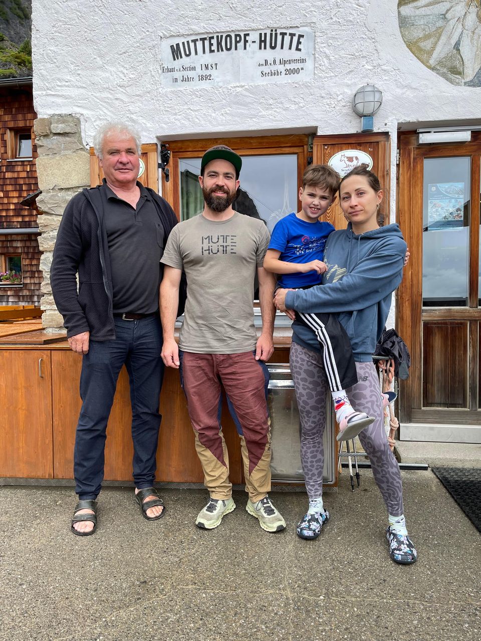 Vier Menschen stehen vor der Hütte